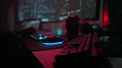 Hacker in gloves types on back-lit keyboard coding program Stock Footage 257806138