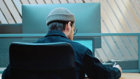 The hacker hacks the program. Drinking a drink from a mug. Back view Stock Footage 172258543