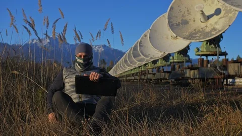 Hacker hacks the radio telescope using notebook. Man to program hacking on Stock Footage 98502611