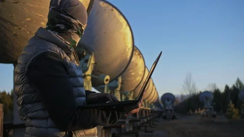 Hacker hacks the radio telescope using notebook. Man to program hacking on Video stock 98502871