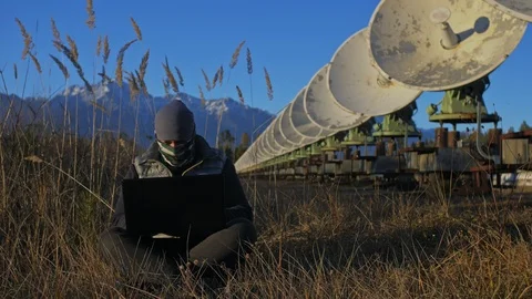 Hacker hacks the radio telescope using notebook. Man to program hacking on Stock Footage 98802732