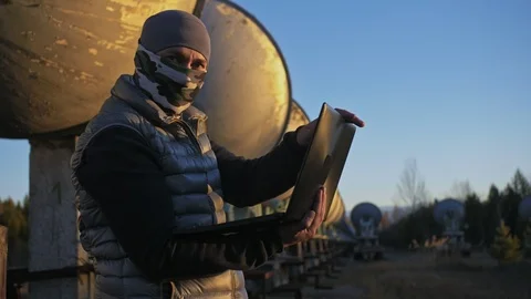 Hacker hacks the radio telescope using notebook. Man to program hacking on Video stock 98802856