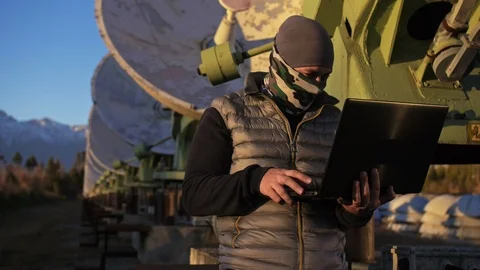 Hacker hacks the radio telescope using notebook. Man to program hacking on Video stock 99743083
