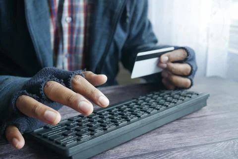Hacker hand stealing data from credit card Stock Photos