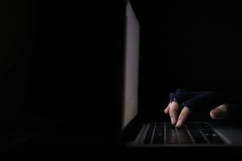 Hacker hand stealing data from laptop isolated on black Foto stock