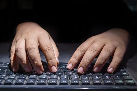 Hacker hand typing on a computer keyboard Stock Photos
