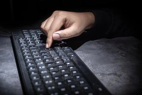 Hacker hand typing on a computer keyboard Stock Photos
