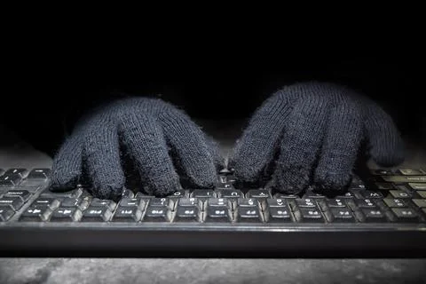 Hacker hand typing on a computer keyboard Stock Photos