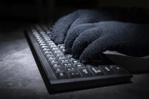 Hacker hand typing on a computer keyboard Stock Photos