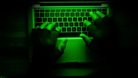 Hacker hands in fingerless gloves typing on laptop keyboard with green scre.. Stock Footage 332745824