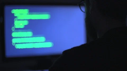 Hacker as he sits at a computer Stock Footage 92525158