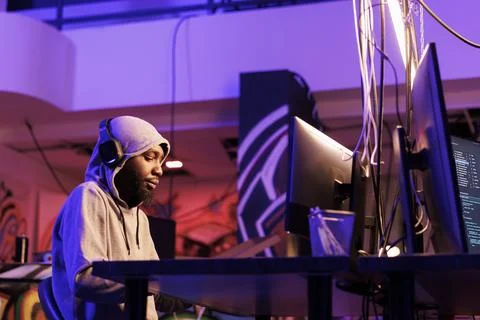 Hacker in headphones coding malware Stock-Fotos