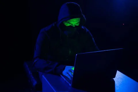 Hacker hiding his face on dark background Foto stock