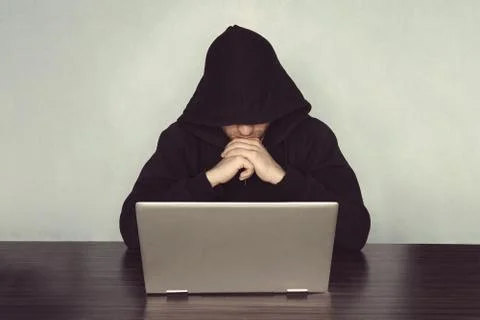  Hacker with his computer thinking on light blue background. monk hermit pray Stockfoto's