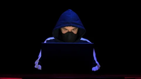 Hacker in hood and mask coding and programming using laptop. Cybercrime concept Stock Footage 129299290