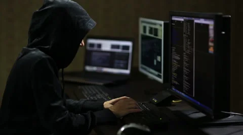 Hacker in hood cracking code using laptop and computers Stock Footage 45975312