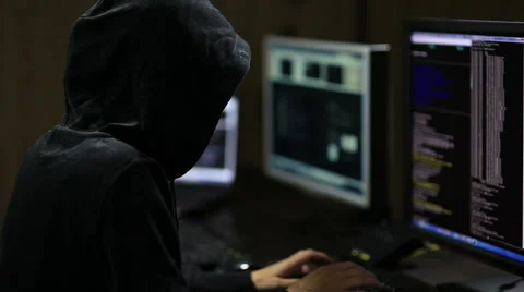 Hacker in hood cracking code using laptop and computers Stock Footage 45975331