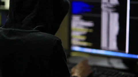 Hacker in hood cracking code using laptop and computers Stock Footage 45975342