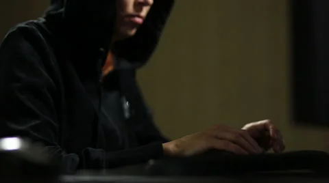 Hacker in hood cracking code using laptop and computers Stock Footage 45975353