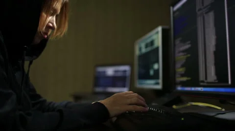 Hacker in hood cracking code using laptop and computers Stock Footage 45975368