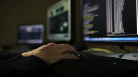 Hacker in hood cracking code using laptop and computers Stock Footage 45975373