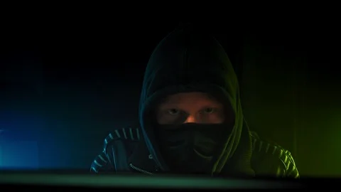 Hacker in hood cracking code using computers from his dark hacker room Stock Footage 112131203