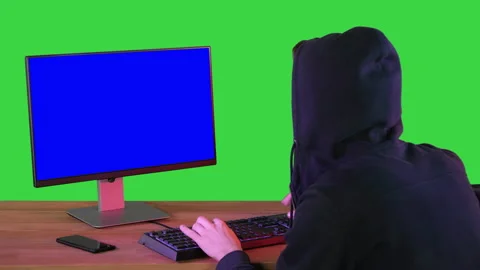 Hacker in hood cracking code using pc on a Green Screen, Chroma Key. Stock Footage 138541034