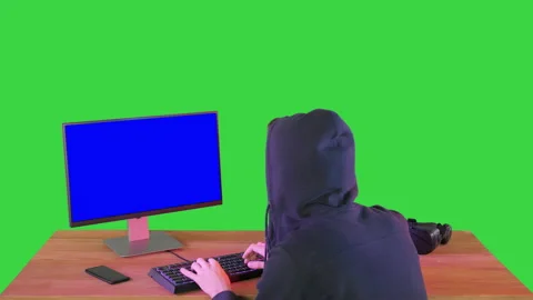 Hacker in hood cracking code using pc on a Green Screen, Chroma Key. Stock Footage 140013722
