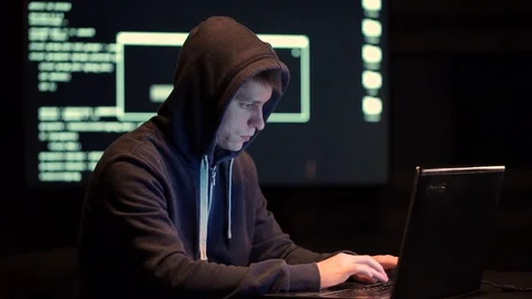 The Hacker in a Hood with Notebook Cracks a Computer Code Stock Footage 70817340