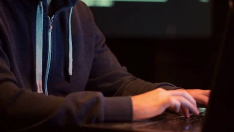 The Hacker in a Hood with Notebook Cracks a Computer Code Video stock 70817629
