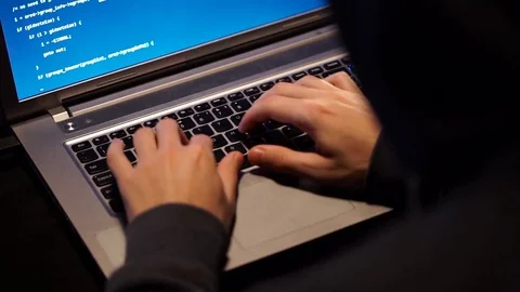 The Hacker in a Hood with Notebook Cracks a Computer Code Stock Footage