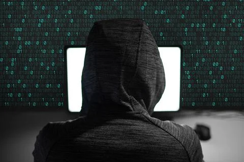 The hacker in the hood works at the computer. Web attack in a virtual environ Stock Photos