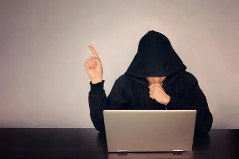  Hacker hooded in front of his computer show finger. Dark face. hooded .techn Stock Photos