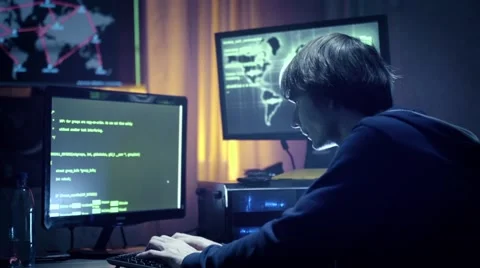 Hacker in hooded jacket using computer at table Stock Footage 60605680