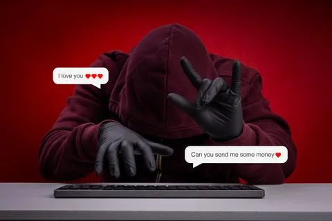 Hacker in hoodie and gloves using online romance scam tactics, sending fake.. Stock Photos