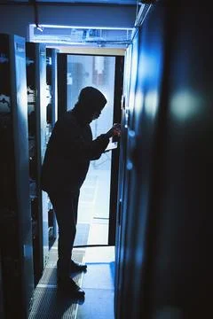 Hacker, hoodie and tablet in server room at night for coding, cyberattack a.. Foto stock