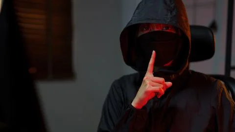Hacker in hoodie hacking programming system or data of server on computer a.. Stock Photos