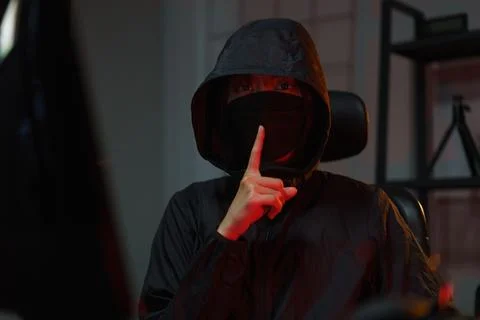 Hacker in hoodie hacking programming system or data of server on computer a.. Stock Photos