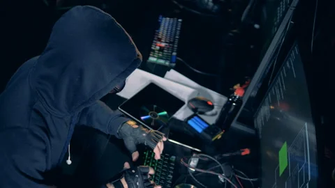 Hacker in a hoodie is operating computers Stock Footage 101577390