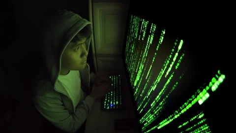 Hacker in Hoodie Using Computer with Green Code in Dark Room for Cybersecurity Stock Footage 336049699