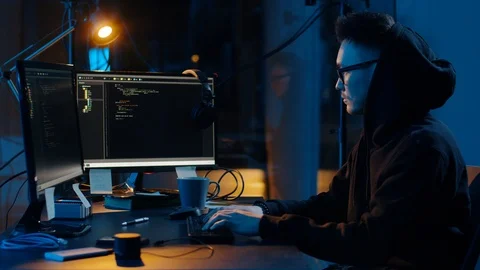 Hacker in hoodie using computers for cyber attack Stock Footage 107379023