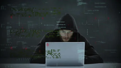 Hacker in hoodie using laptop with cybersecurity threat animation over code Stock Footage 303739890