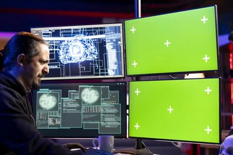 Hacker installing spyware using green screen PC and AI to secretly gather data Stock Photos