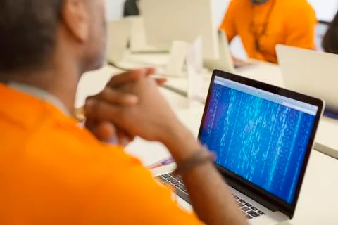 Hacker at laptop coding for charity at hackathon Stockfoto's