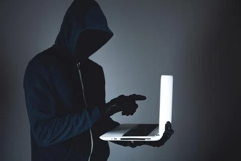 Hacker with laptop. Computer crime. Stock Photos