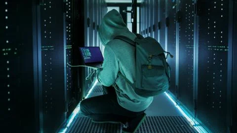 Hacker With Laptop Connects to Rack Server and  Steals Information from Corpo Stock Photos