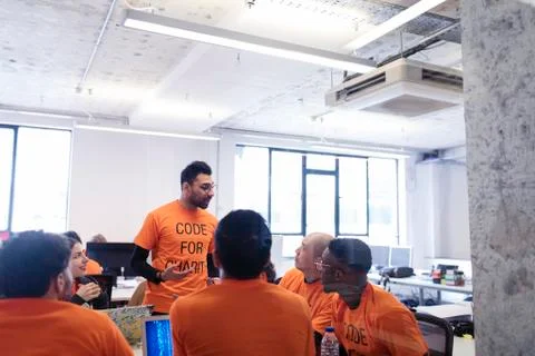 Hacker leading discussion, coding for charity at hackathon Stock Photos
