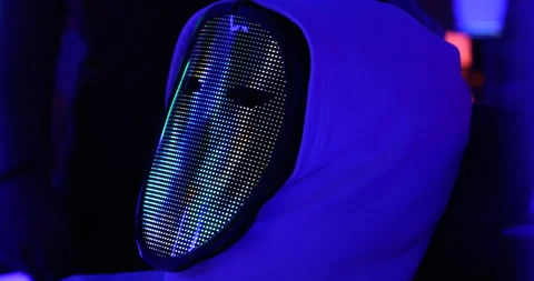 Hacker with LED Mask Working On Computers Stock Footage 260447586