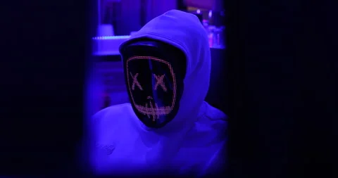 Hacker with LED Mask Working On Computers Stock Footage 260447686