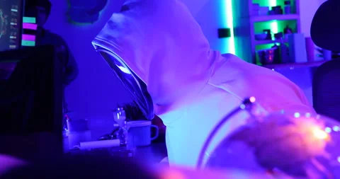 Hacker with LED Mask Working On Computers Stock Footage 260448123